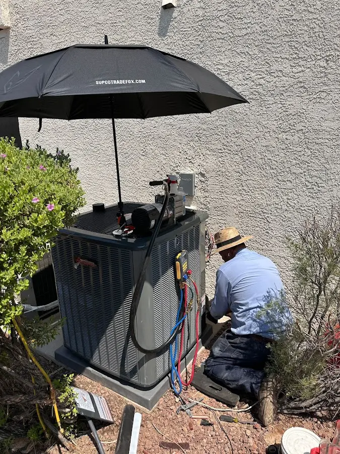 HVAC technician performing outdoor AC maintenance in Rio Rancho